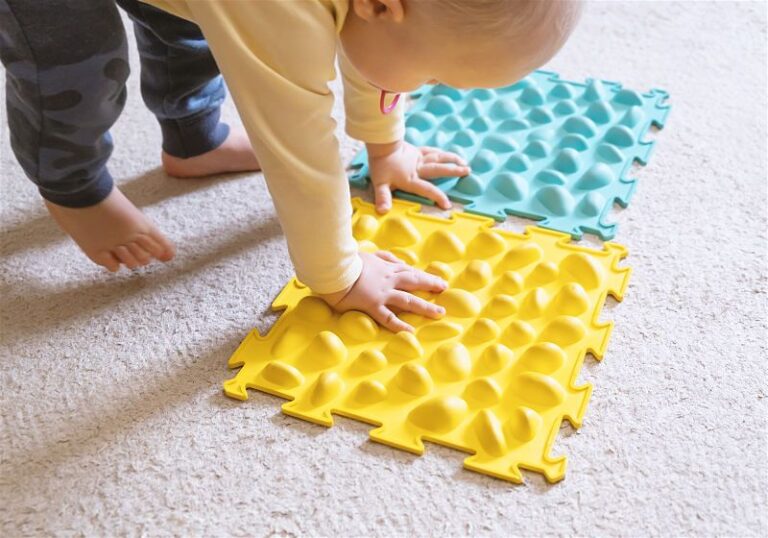 Bebê brincando com tapete de borracha com textura