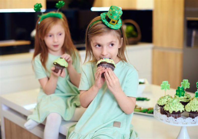 Duas meninas sentadas e comendo cupcake
