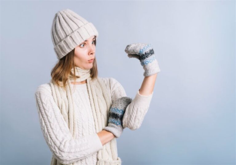 Mulher com roupa de frio e luva, imitando fantoche com as mãos