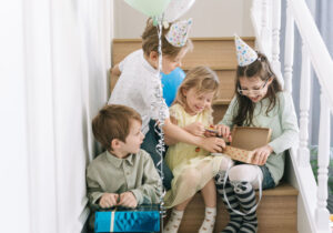 crianças em festa de aniversário brincando com caixa de papelão pequena